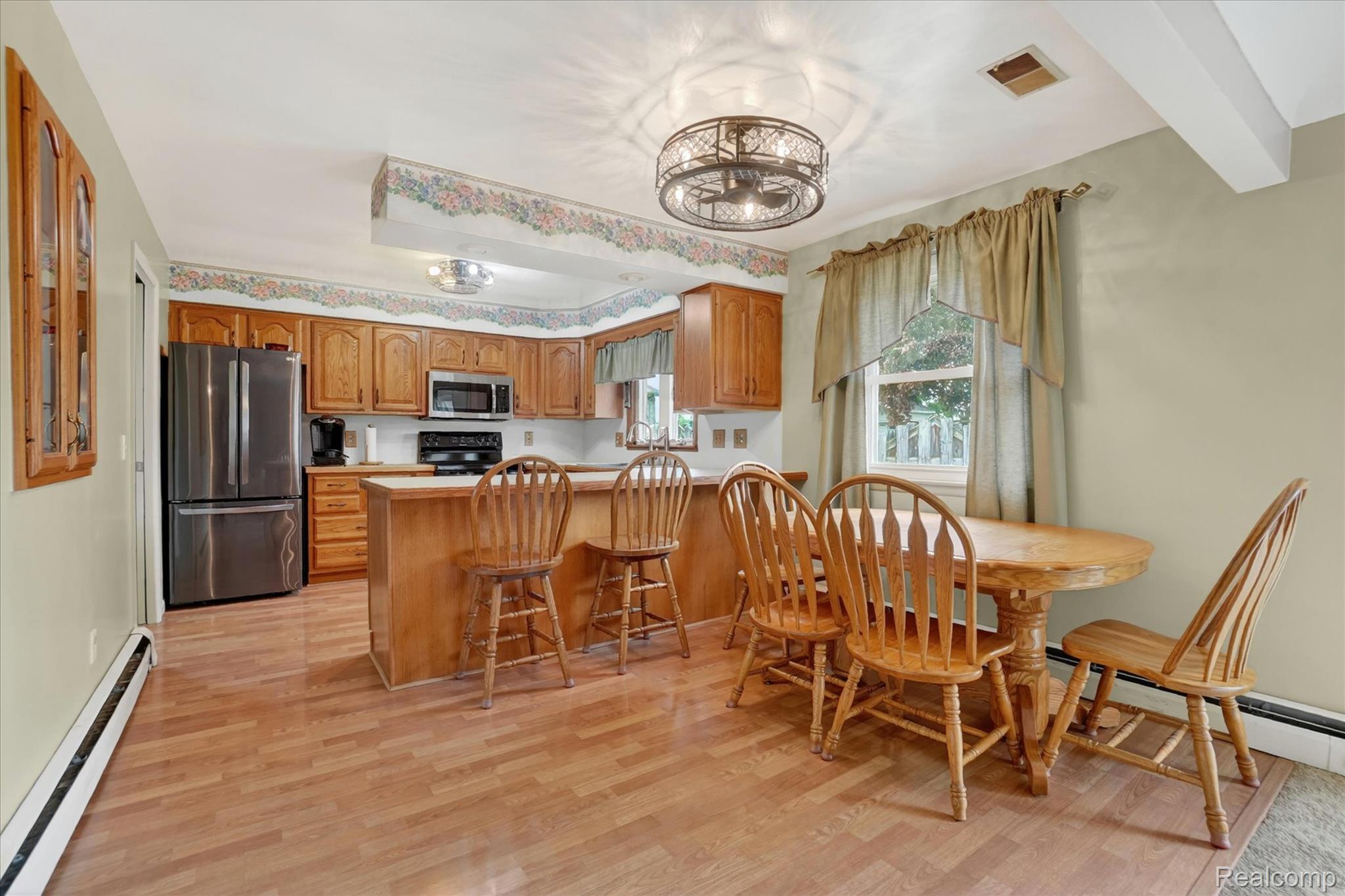 7358 Morrish Road Swartz Creek, MI 48473 - Photo 16 of 39 Dining space with a baseboard heating unit, light wood-style flooring, beamed ceiling, and a baseboard radiator