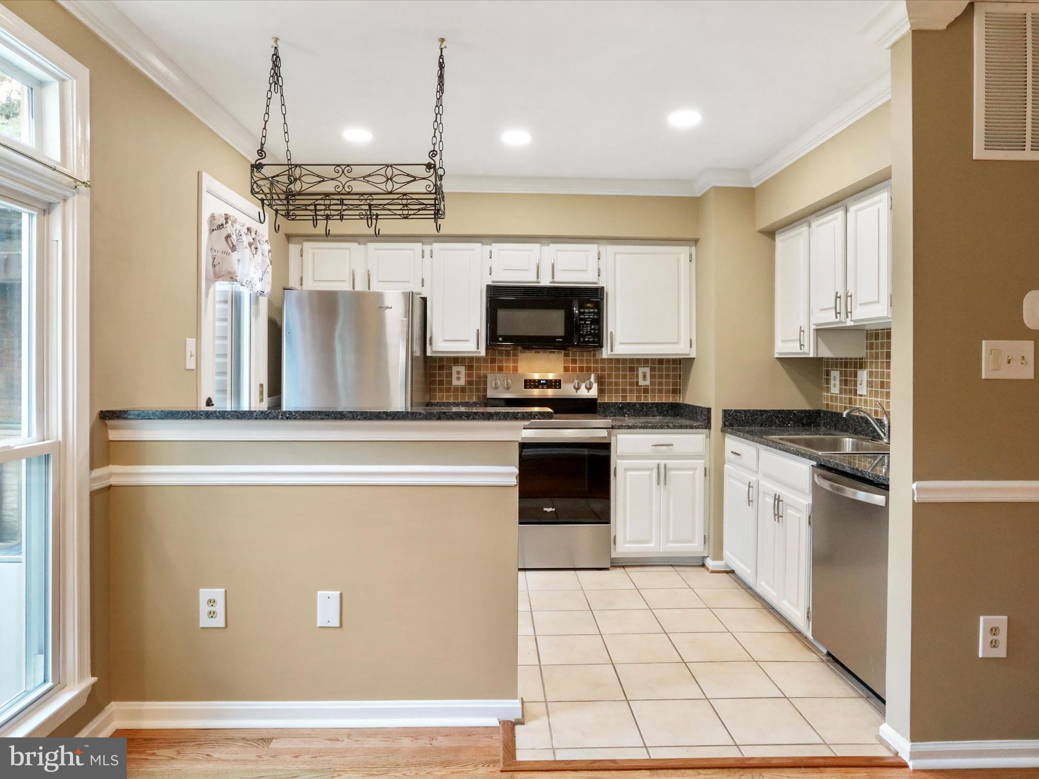 6910 Compton Valley Court Centreville, VA 20121 - Photo 11 of 37 a kitchen with stainless steel appliances a refrigerator stove top oven and sink