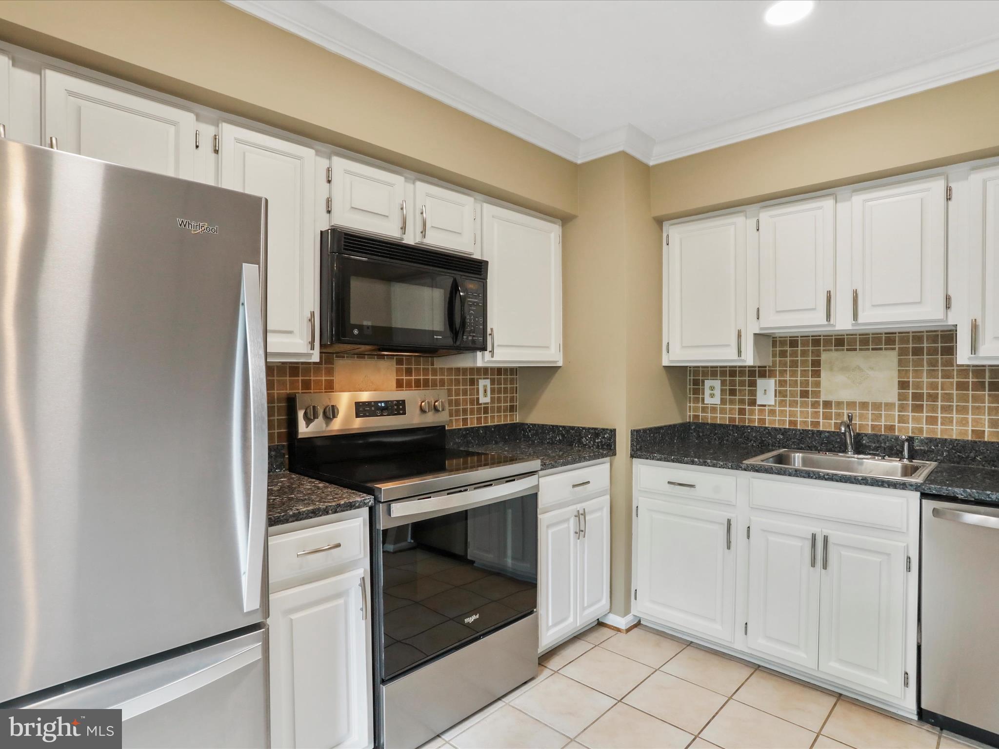 6910 Compton Valley Court Centreville, VA 20121 - Photo 12 of 37 a kitchen with stainless steel appliances granite countertop a stove a sink and a microwave