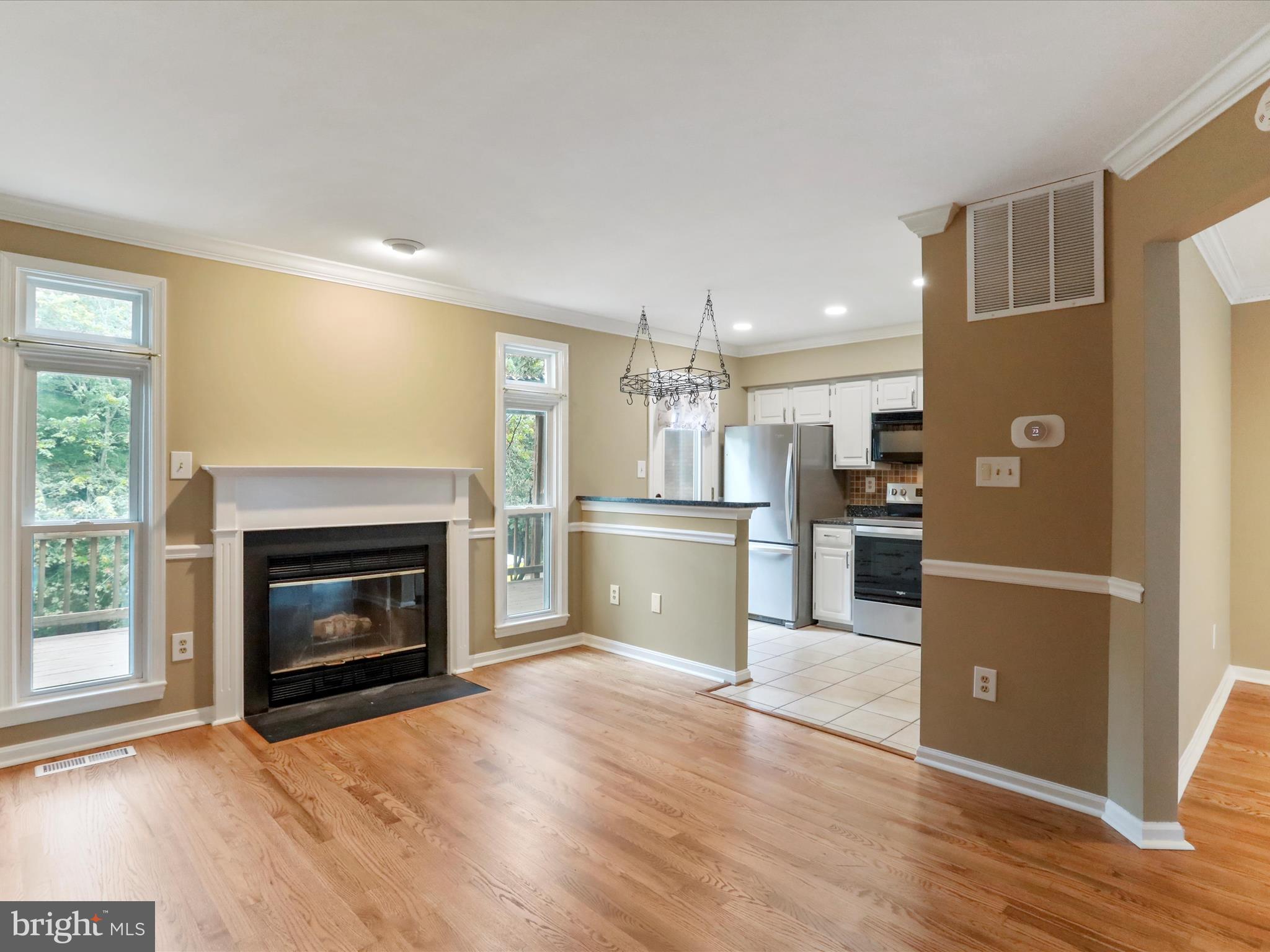 6910 Compton Valley Court Centreville, VA 20121 - Photo 10 of 37 a kitchen with granite countertop wooden floors and stainless steel appliances