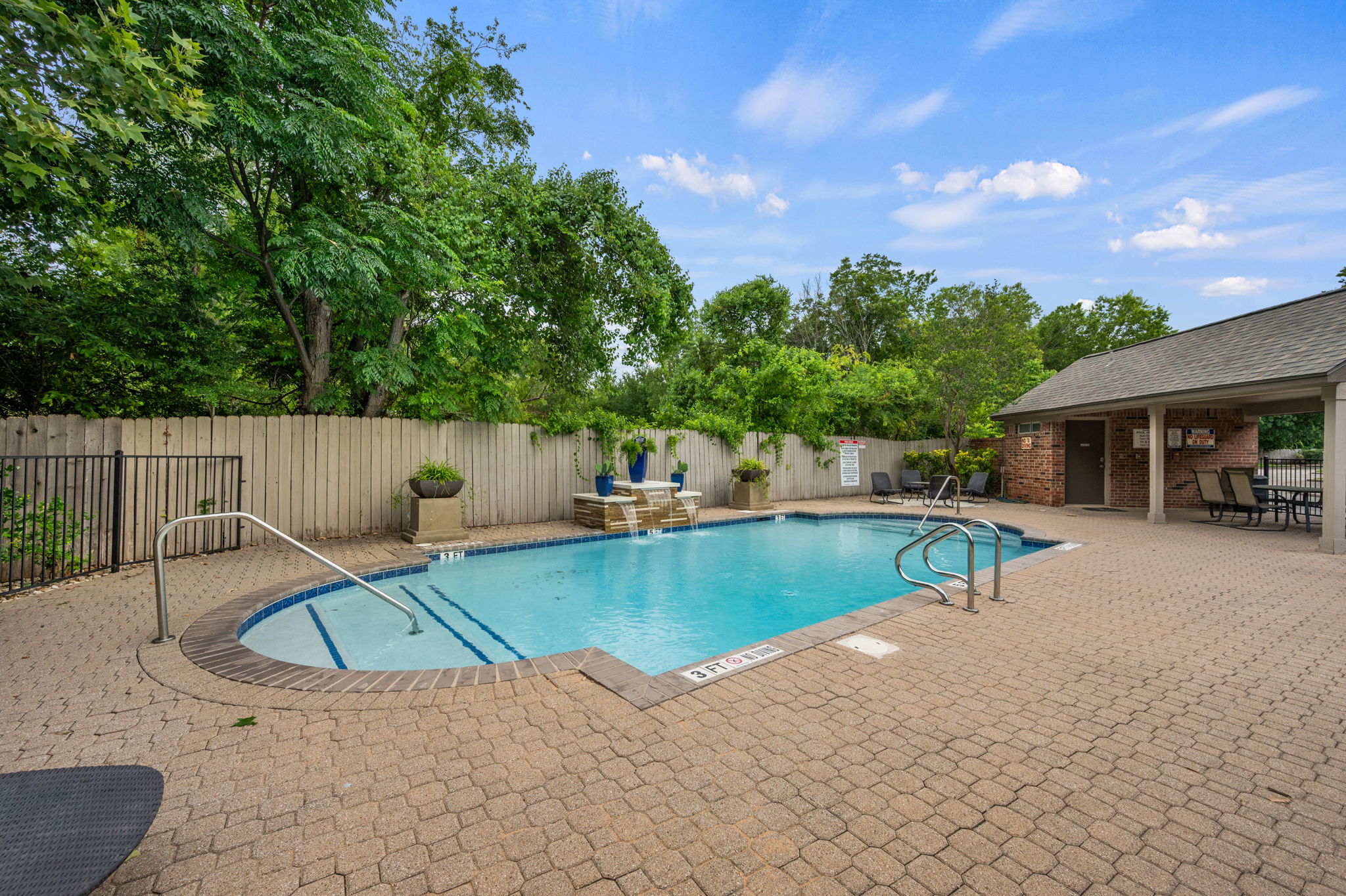 12401 Los Indios Trail, Unit 32 Austin, TX 78729 - Photo 30 of 39 A sparkling pool with water features offers a refreshing retreat, complemented by ample paved lounging space.