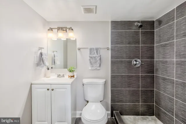 a bathroom with a toilet sink shower and mirror