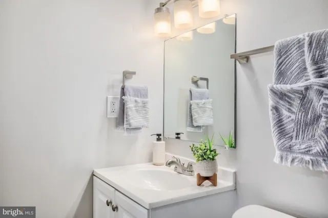 a bathroom with a sink vanity mirror and toilet