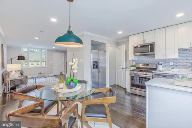 a kitchen with stainless steel appliances a dining table chairs and kitchen view