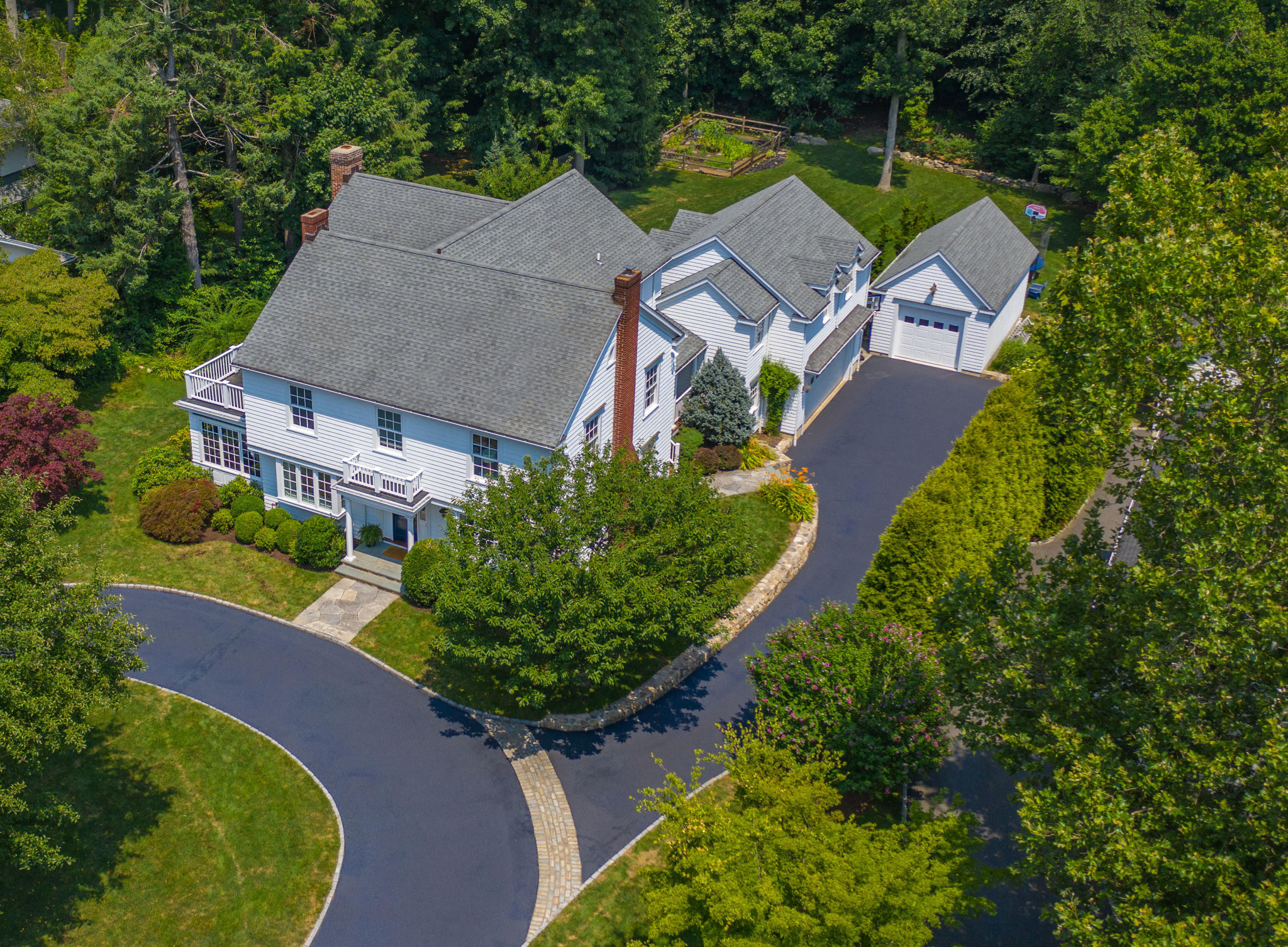 an aerial view of a house with a yard and a large tree