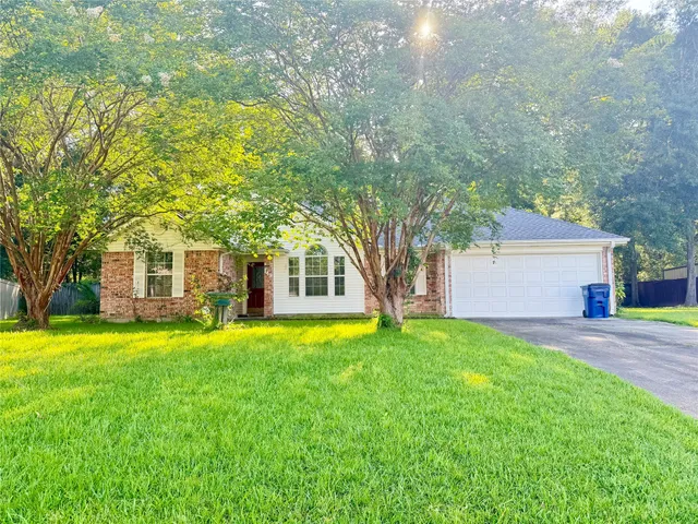 a view of a house with a big yard and large trees