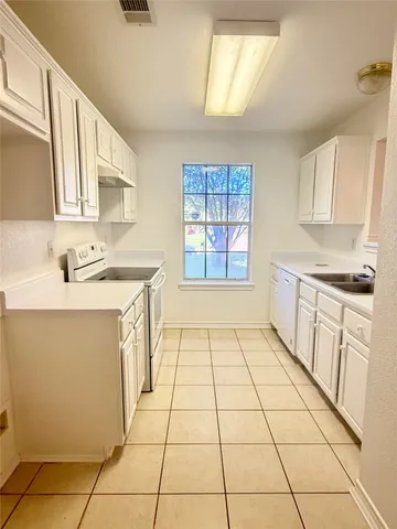 a kitchen with a sink a stove top oven and cabinets