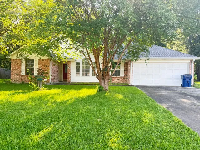 a view of a house with a big yard and large tree