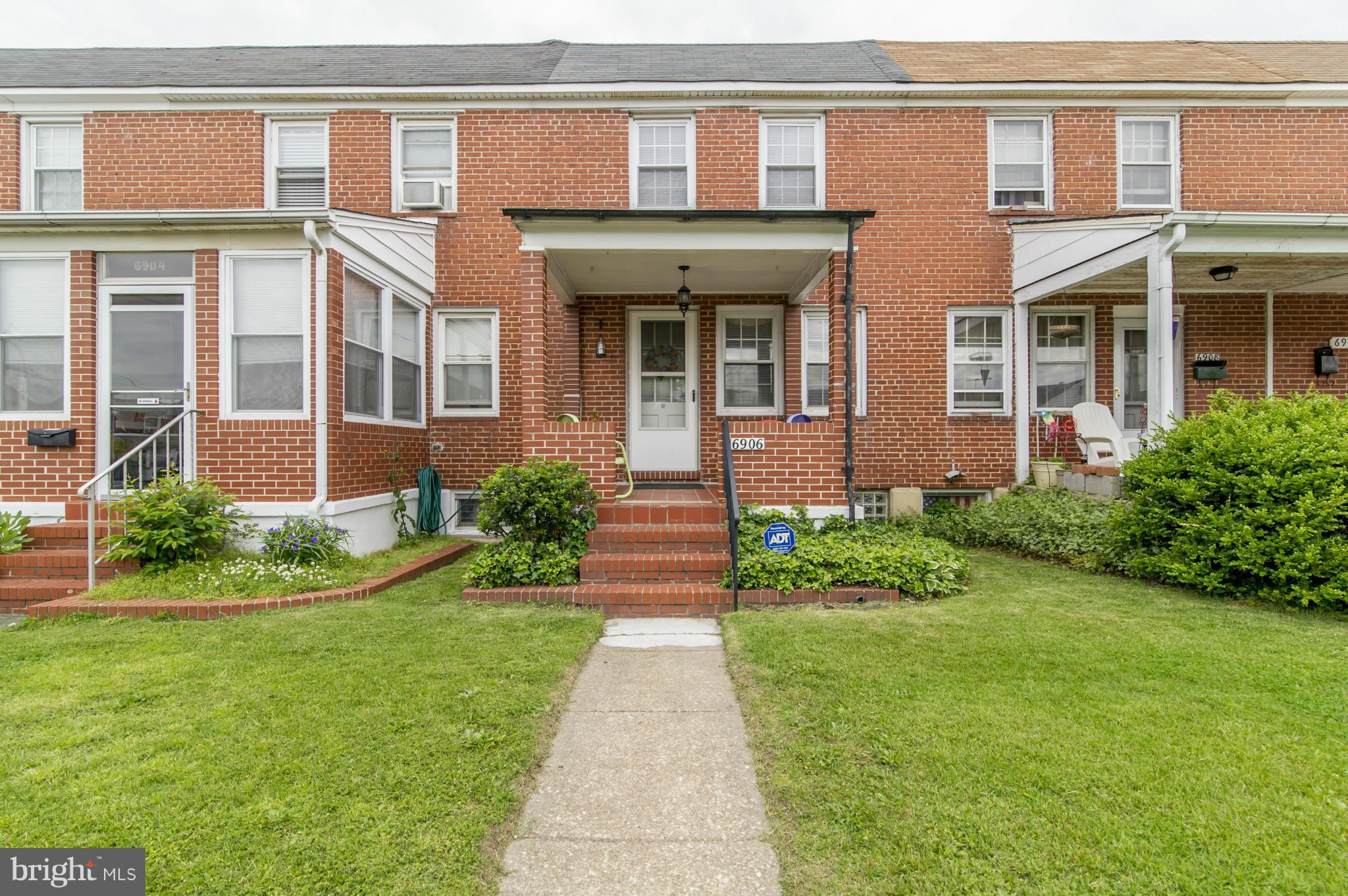 front view of a brick house with a yard