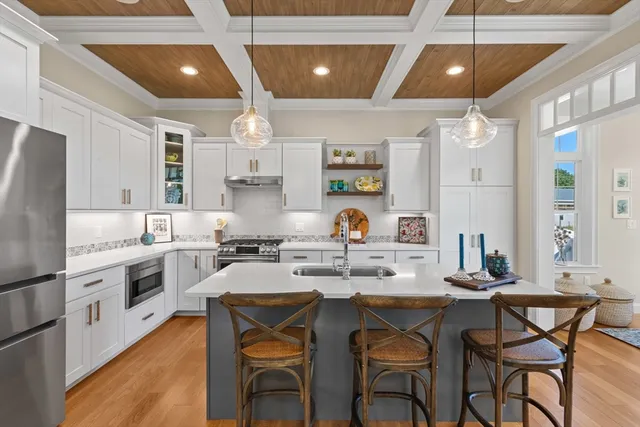 a kitchen with a dining table chairs stainless steel appliances and cabinets