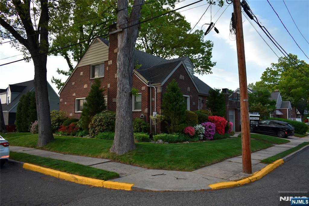 585 Monroe Place Ridgefield, NJ 07657 - Photo 3 of 28 a front view of a house with a yard and potted plants