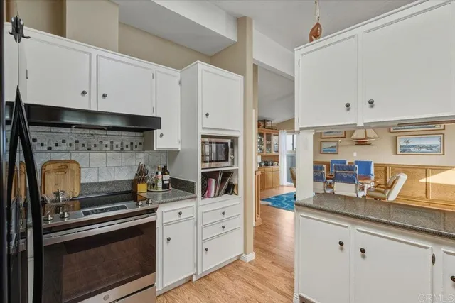 a kitchen with granite countertop a stove and a sink
