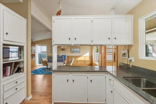 a kitchen with counter top space and windows