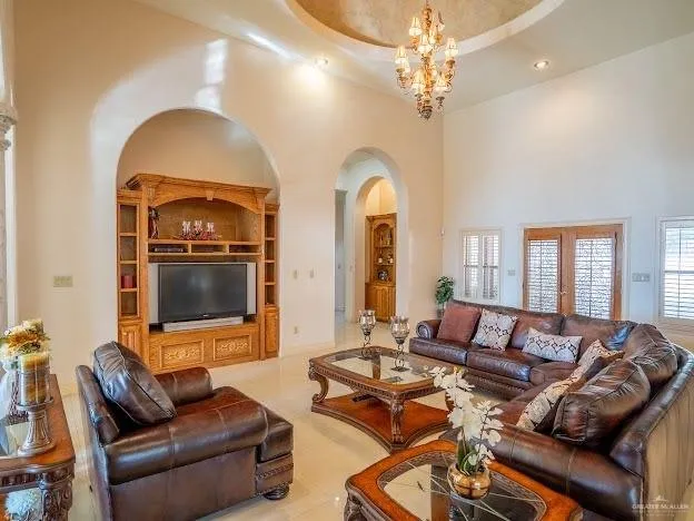 a living room with furniture a chandelier and a flat screen tv