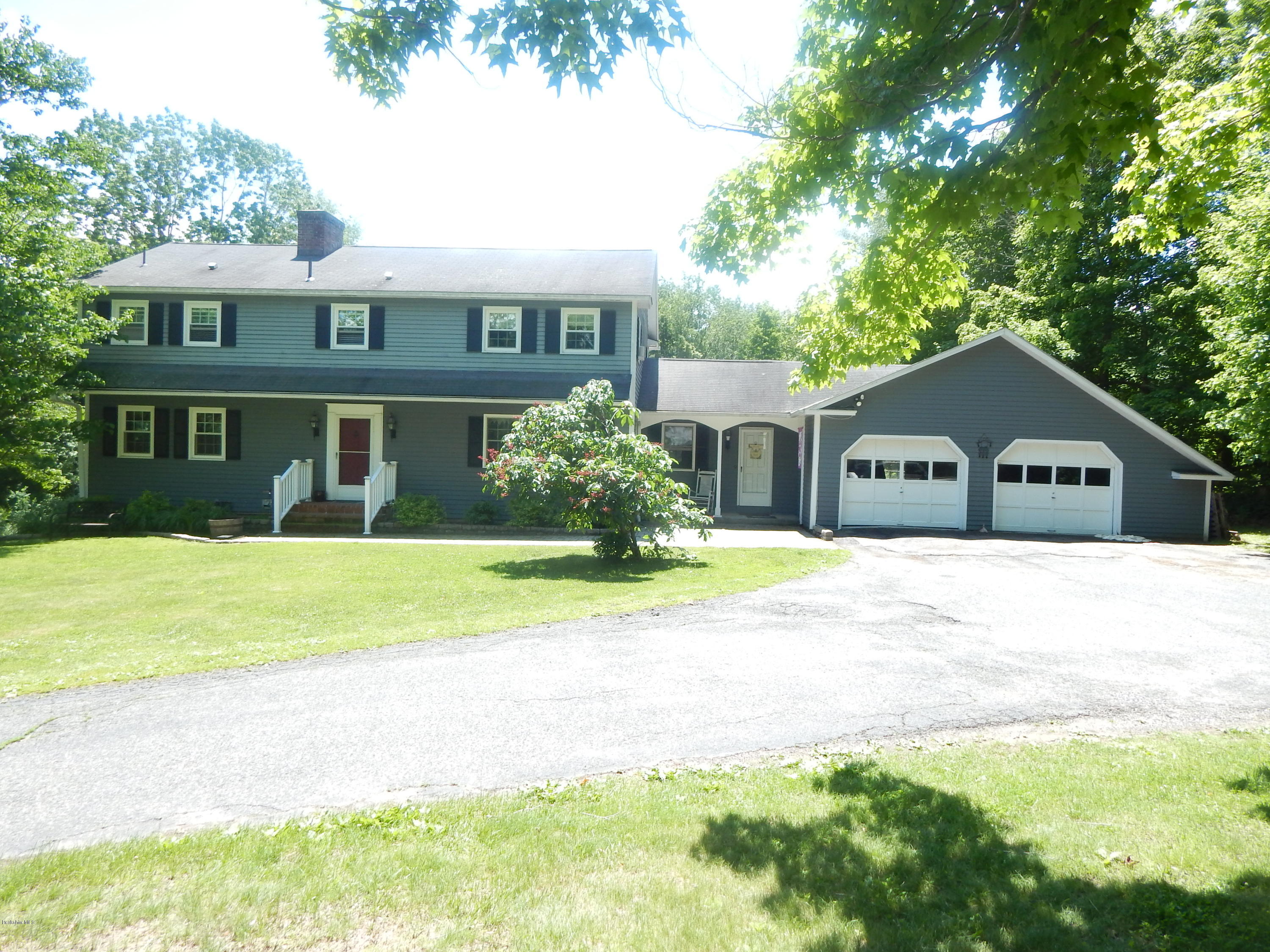 425 Devon Road Lee, MA 01238 - Photo 1 of 35 a front view of a house with a yard and garage