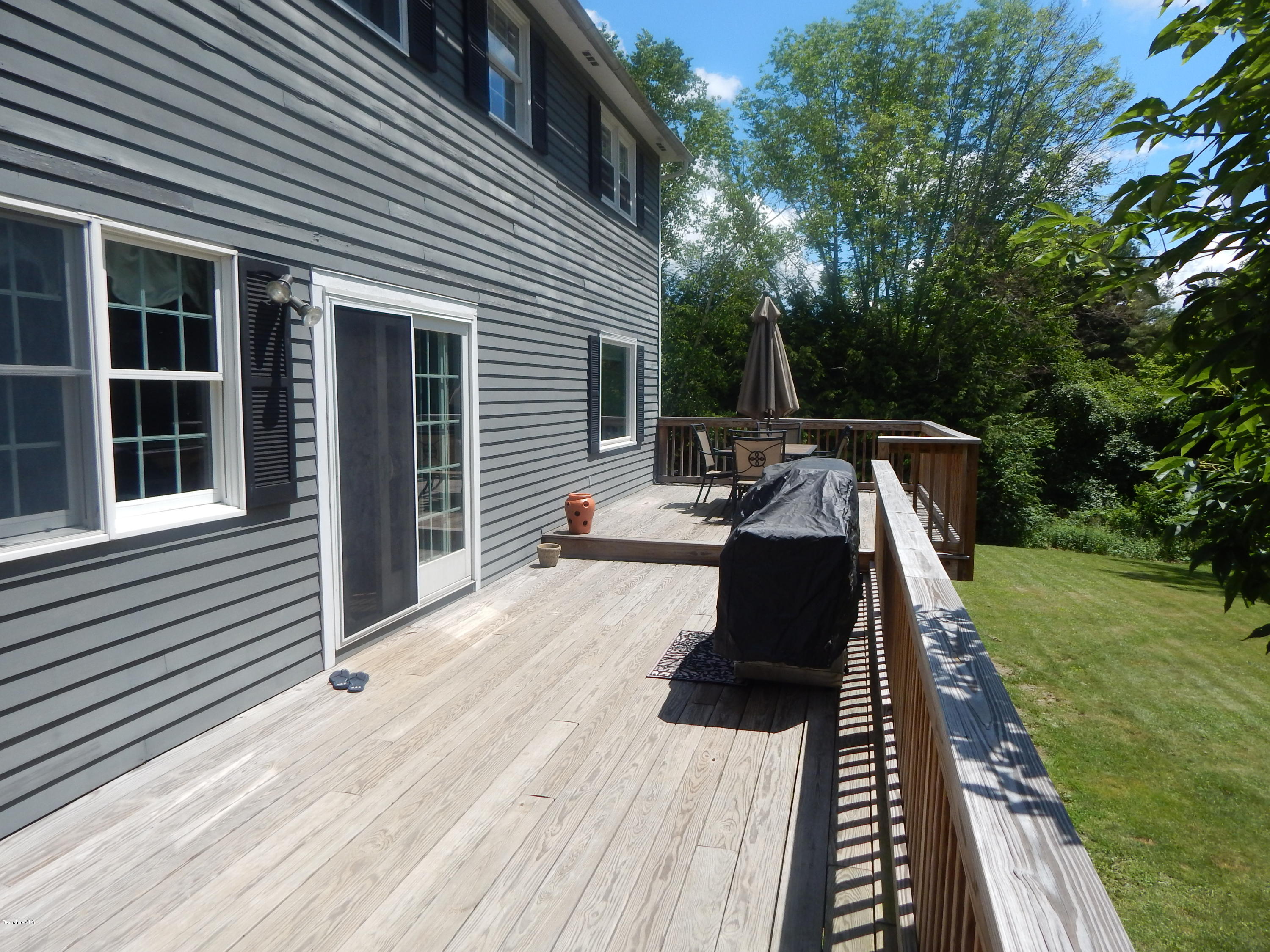 425 Devon Road Lee, MA 01238 - Photo 29 of 35 a view of a patio with table and chairs with wooden floor and fence