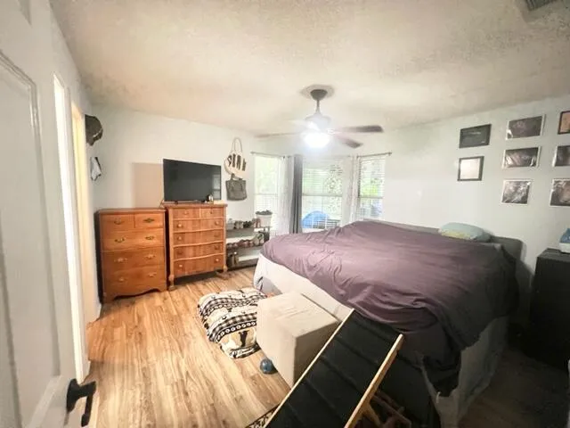 a spacious bedroom with a bed and a flat screen tv