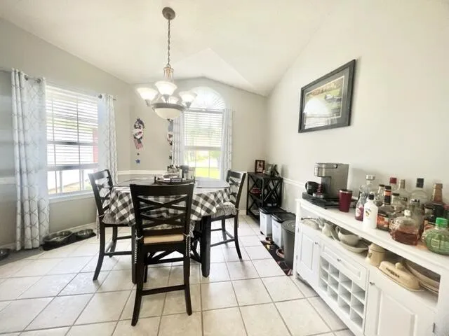a kitchen with stainless steel appliances kitchen island granite countertop dining table chairs and white cabinets