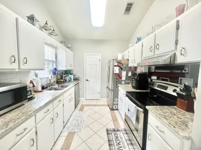 a kitchen with stainless steel appliances granite countertop a stove and a sink