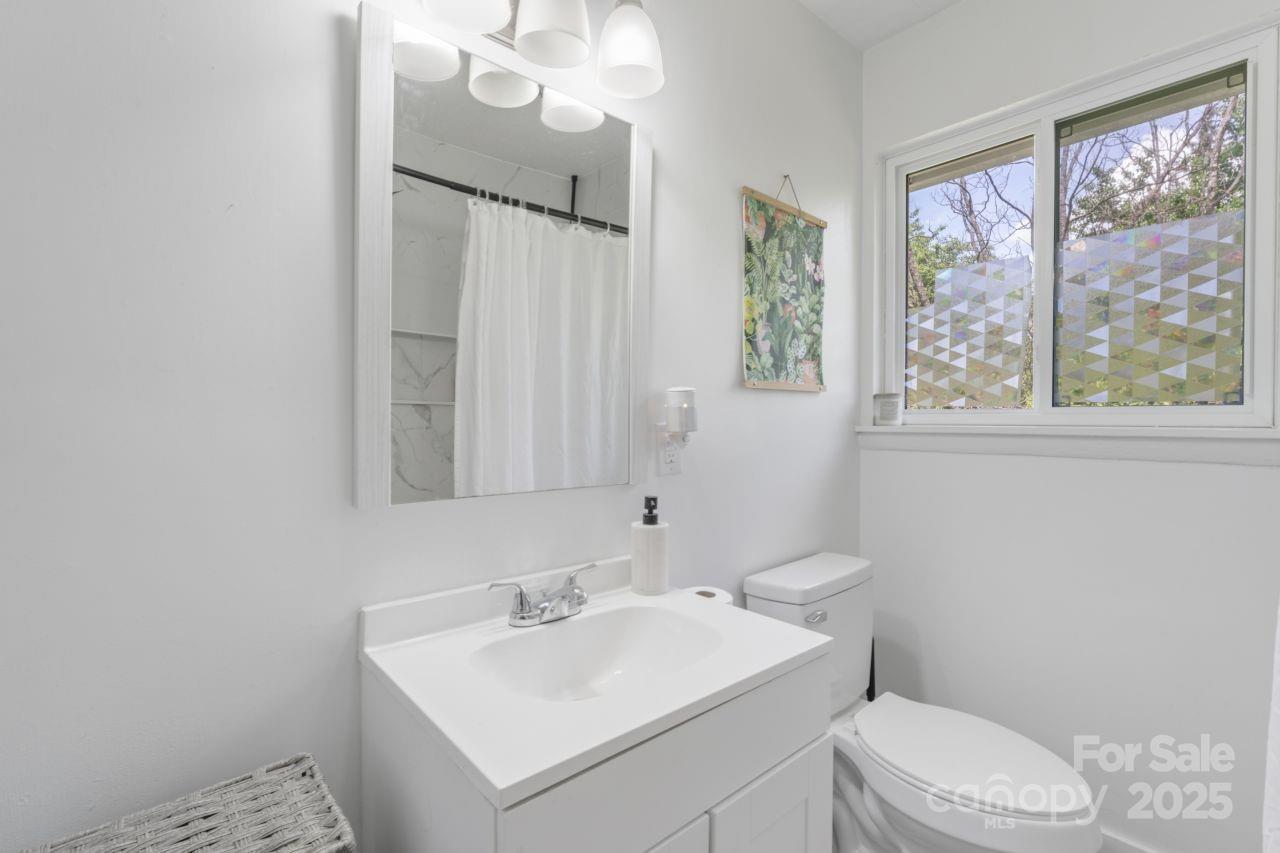 2403 Earley Circle Kannapolis, NC 28083 - Photo 14 of 21 a bathroom with a toilet a sink a mirror a window and vanity