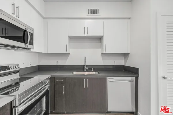 a kitchen with stainless steel appliances granite countertop a sink stove and microwave