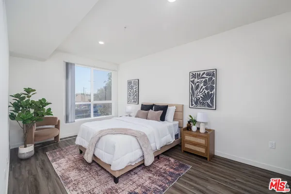 a bedroom with a bed and a potted plant