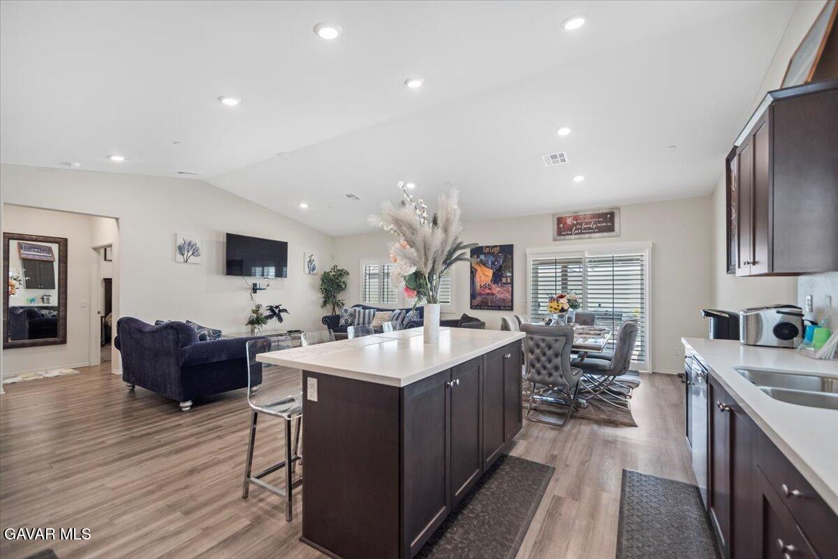 44304 43rd Street West Lancaster, CA 93536 - Photo 11 of 37 a large living room with stainless steel appliances furniture a rug kitchen island a stove a table and chairs