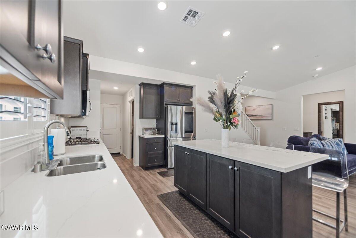 44304 43rd Street West Lancaster, CA 93536 - Photo 12 of 37 a kitchen with kitchen island granite countertop a sink counter top space appliances and cabinets