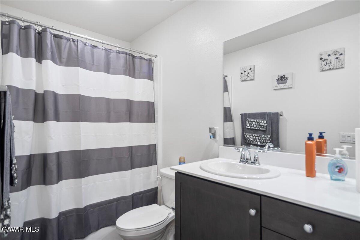 44304 43rd Street West Lancaster, CA 93536 - Photo 31 of 37 a bathroom with a sink a toilet and shower curtain