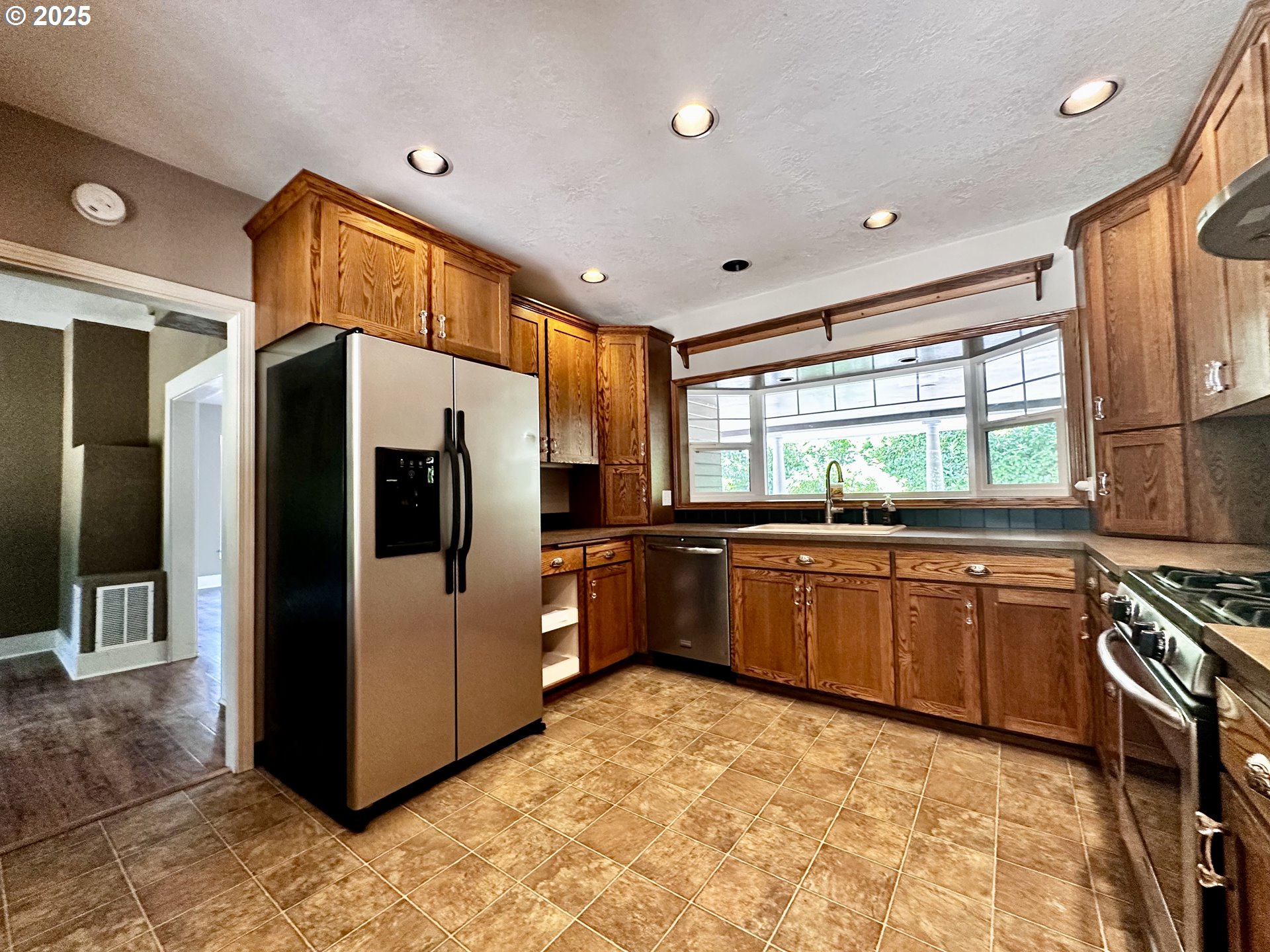2453 Highway 20 Albany, OR 97321 - Photo 14 of 47 a kitchen with stainless steel appliances a refrigerator and wooden cabinets