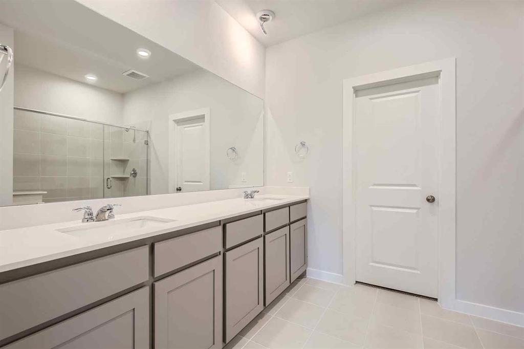 694 Cari Lane Forney, TX 75126 - Photo 13 of 40 a bathroom with double sink and a mirror