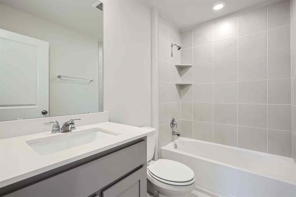 694 Cari Lane Forney, TX 75126 - Photo 16 of 40 a bathroom with a granite countertop sink a toilet and shower