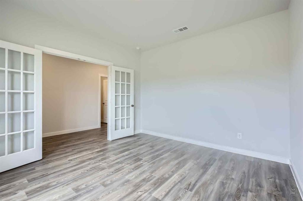 694 Cari Lane Forney, TX 75126 - Photo 6 of 40 a view of an empty room with wooden floor and a window