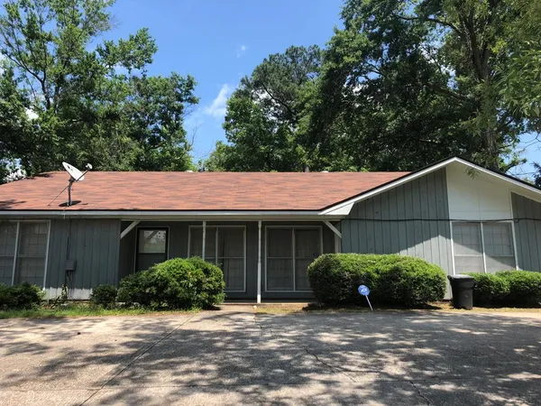 a house that has a tree in front of it