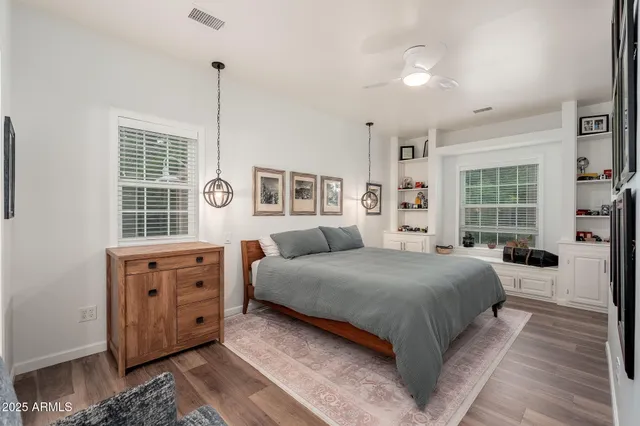 a patio with table and chairs with potted plants and large trees