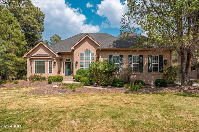 a front view of a house with a yard and trees