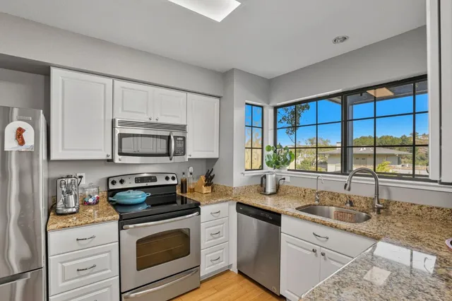 a kitchen with stainless steel appliances a stove sink and cabinets