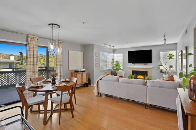 a living room with furniture a flat screen tv and a floor to ceiling window