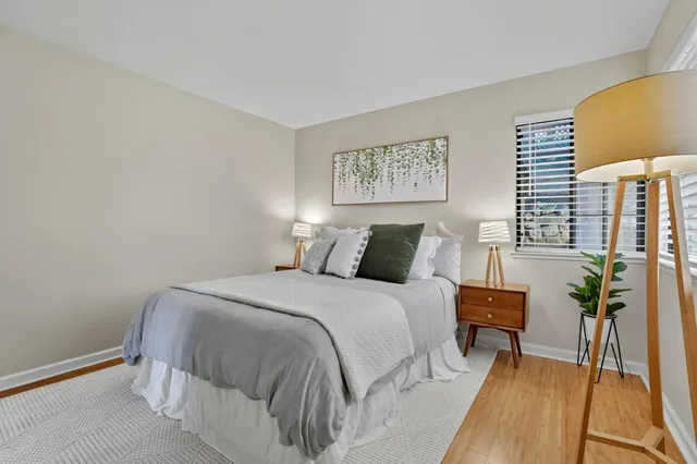 a bedroom with bed and wooden floor