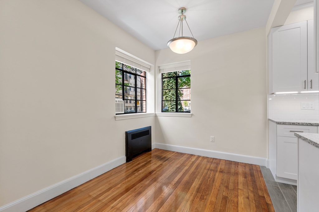 97 Strathmore Road, Unit 1 Boston, MA 02135 - Photo 3 of 16 a view of empty room with wooden floor and fan