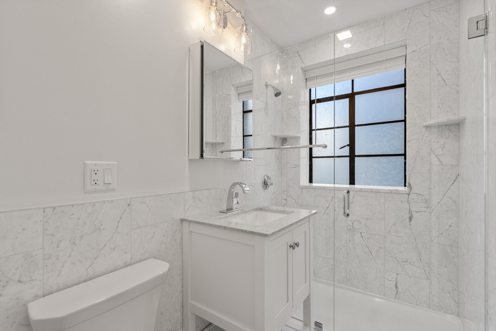 97 Strathmore Road, Unit 1 Boston, MA 02135 - Photo 10 of 16 a bathroom with a sink toilet vanity and shower