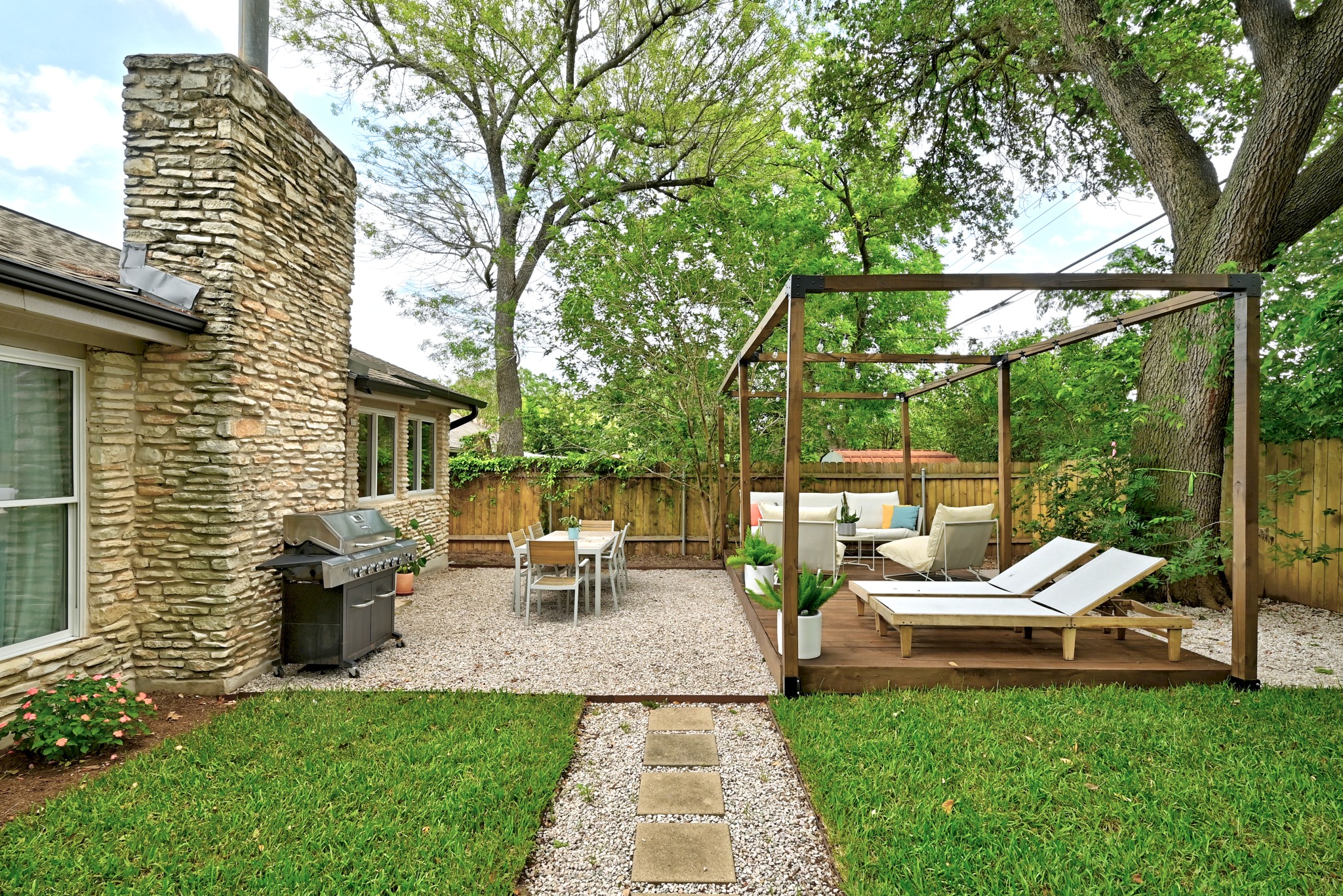 7110 Windrift Way Austin, TX 78745 - Photo 26 of 30 A private backyard oasis features a shaded deck with lounge chairs and a gravel patio for dining.