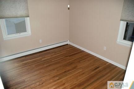 10 Maple Road Iselin, NJ 08830 - Photo 9 of 15 a view of an empty room with wooden floor and a window