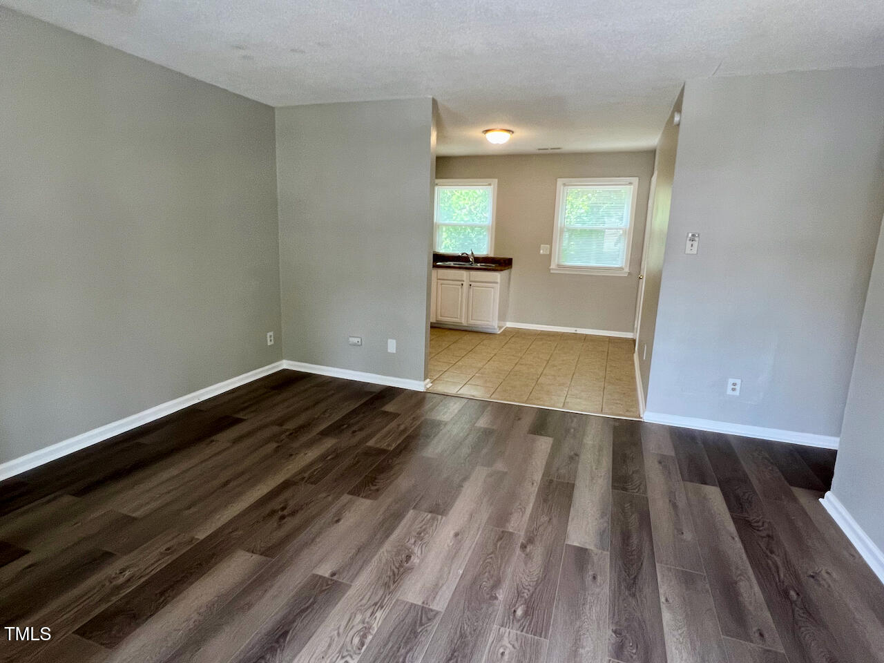 1320 Poole Road, Unit K Raleigh, NC 27610 - Photo 3 of 12 an empty room with wooden floor and windows
