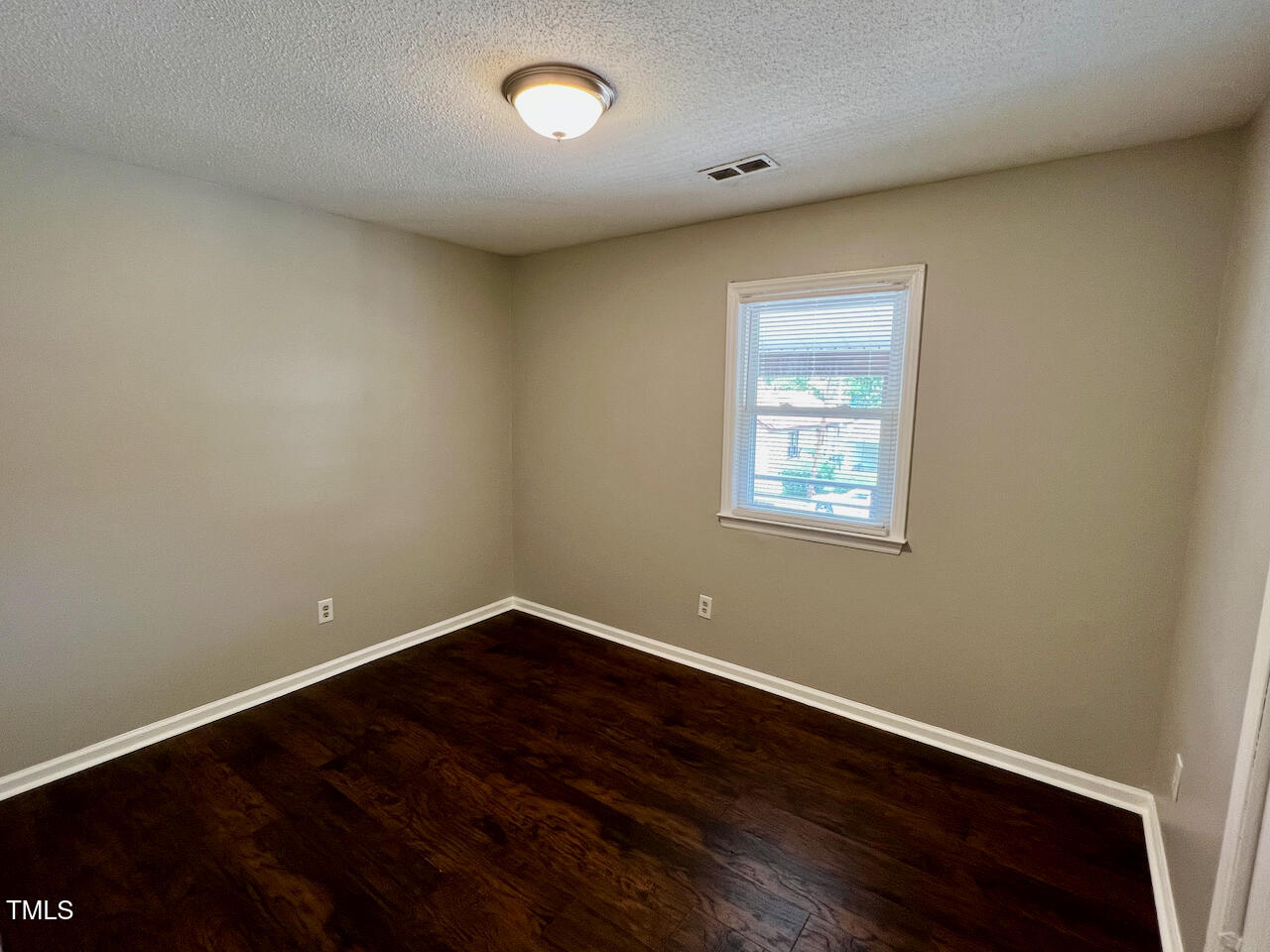 1320 Poole Road, Unit K Raleigh, NC 27610 - Photo 7 of 12 an empty room with wooden floor and windows