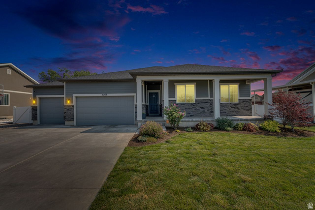 3269 West 650 North Layton, UT 84041 - Photo 4 of 35 Contemporary ranch-style residence featuring a grey exterior with stone accents, a covered front porch, and an attached two-car garage
