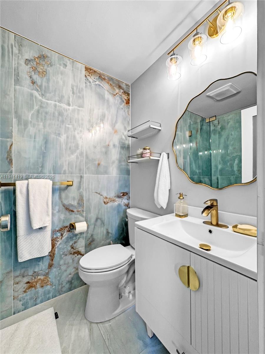 1977 Southwest 15th Street, Unit 116 Deerfield Beach, FL 33442 - Photo 18 of 37 a bathroom with a sink a toilet and a mirror