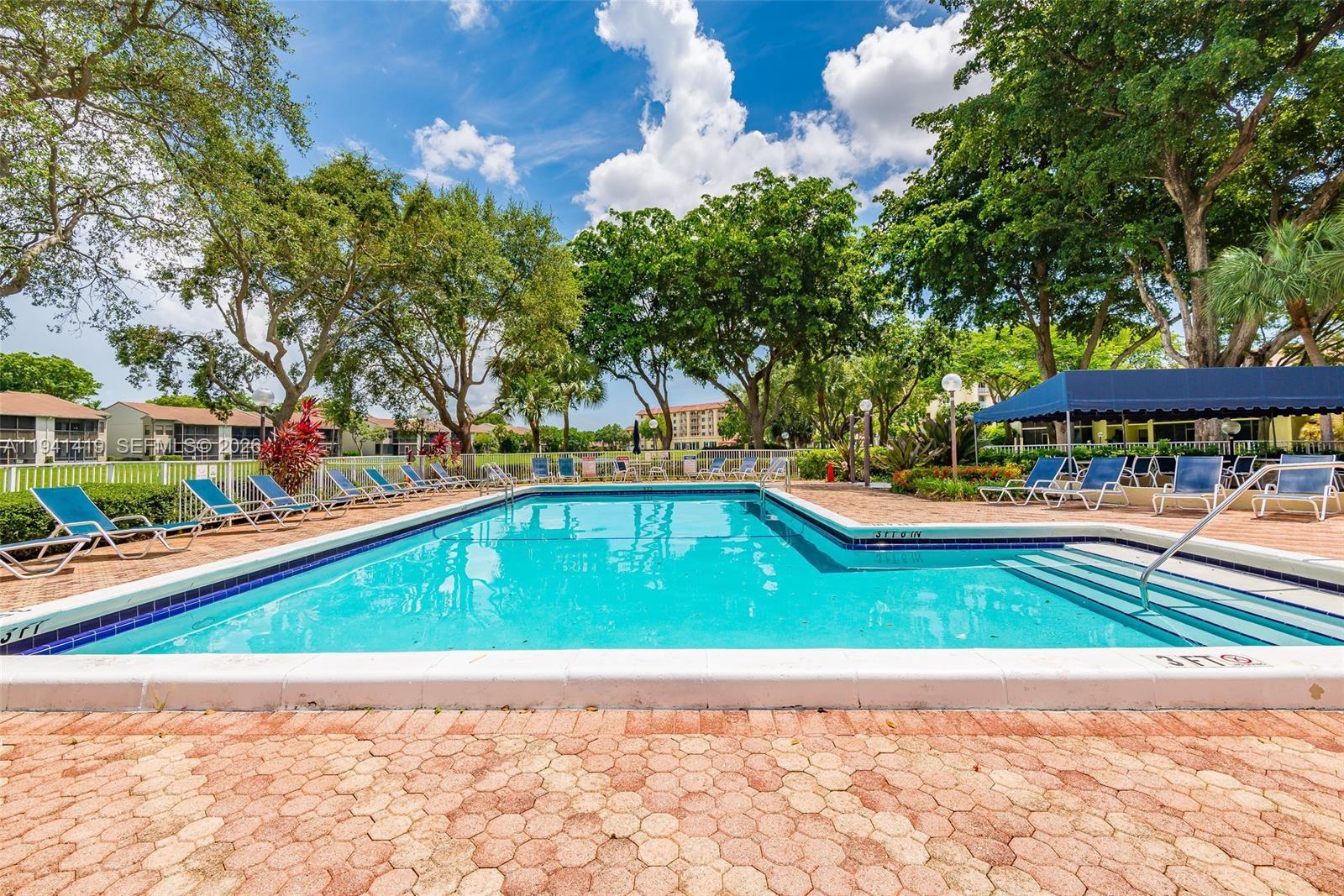 1977 Southwest 15th Street, Unit 116 Deerfield Beach, FL 33442 - Photo 28 of 37 a view of swimming pool with a yard