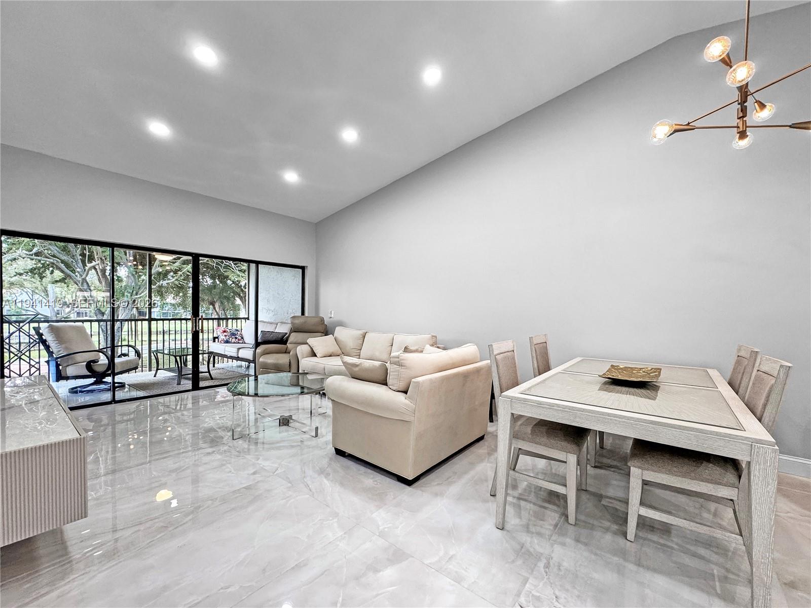 1977 Southwest 15th Street, Unit 116 Deerfield Beach, FL 33442 - Photo 4 of 37 a living room with furniture and a floor to ceiling window