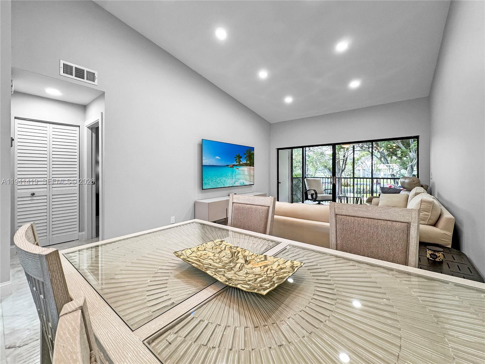 1977 Southwest 15th Street, Unit 116 Deerfield Beach, FL 33442 - Photo 5 of 37 a living room with furniture and a table